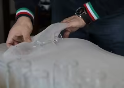 Addetto Iacone Traslochi che avvolge un bicchiere con materiale protettivo per oggetti fragili
